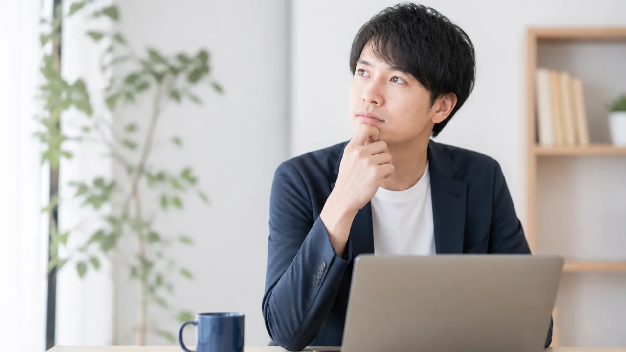 ノートパソコンを前に返事の言葉を考える人のイメージ