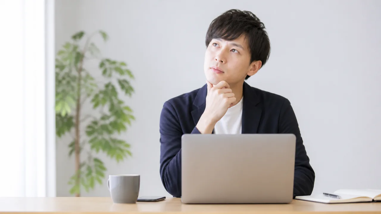 ノートパソコンを前に、仕事を休む制度について考える人のイメージ