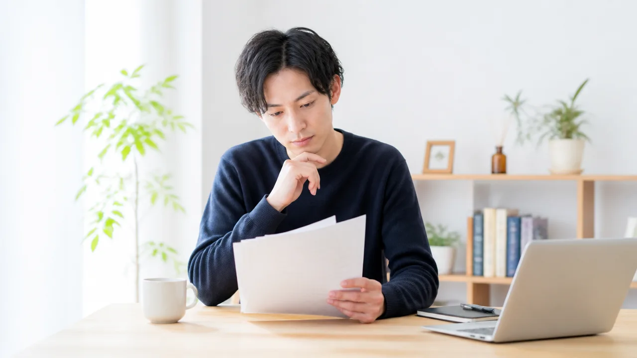 書類を手に、提出する内容を考える人のイメージ