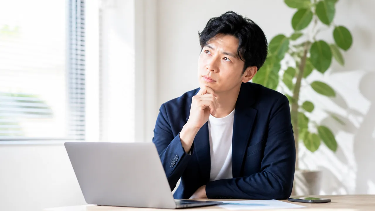 ノートパソコンを前に、給与の条件を考える人のイメージ