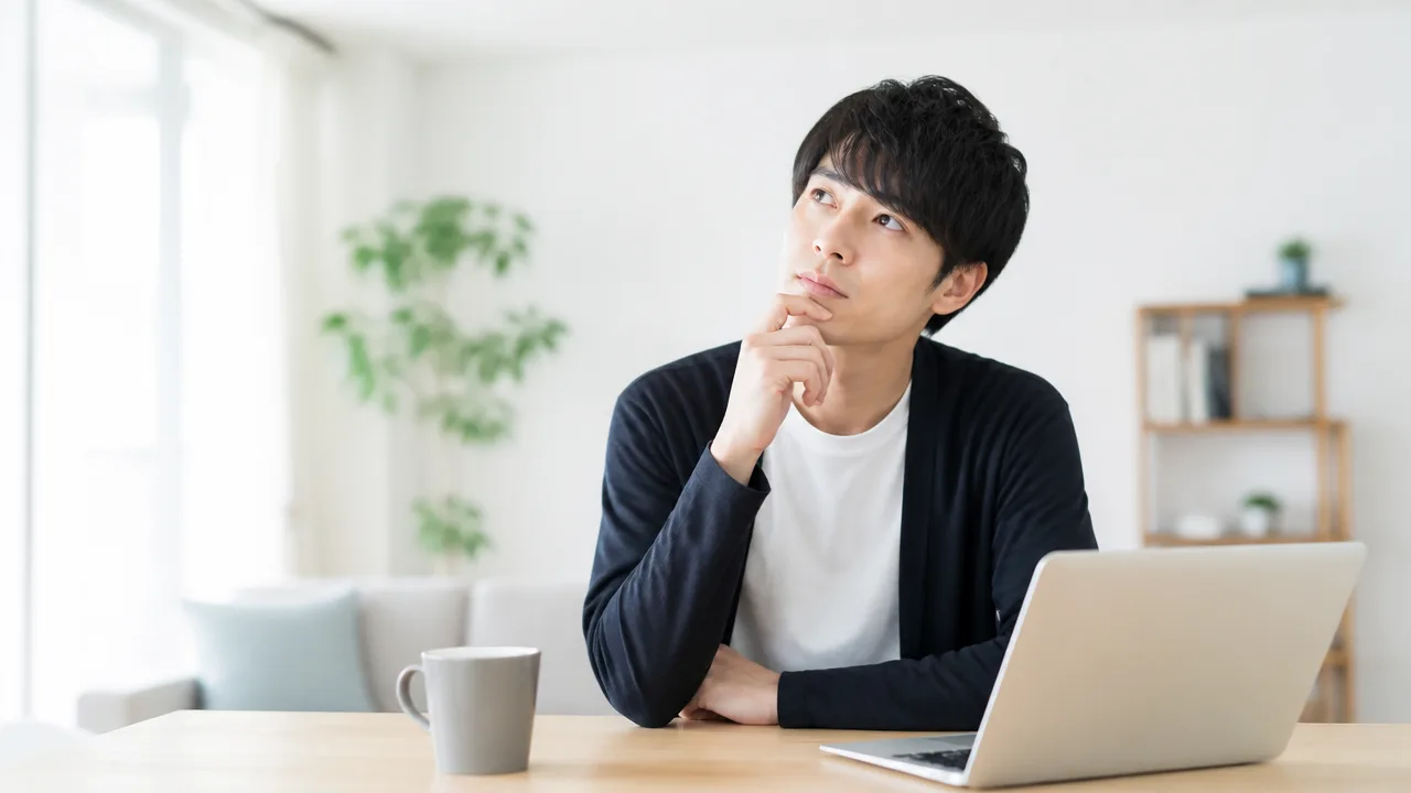 ノートパソコンの前で休みの取り方を考える人のイメージ