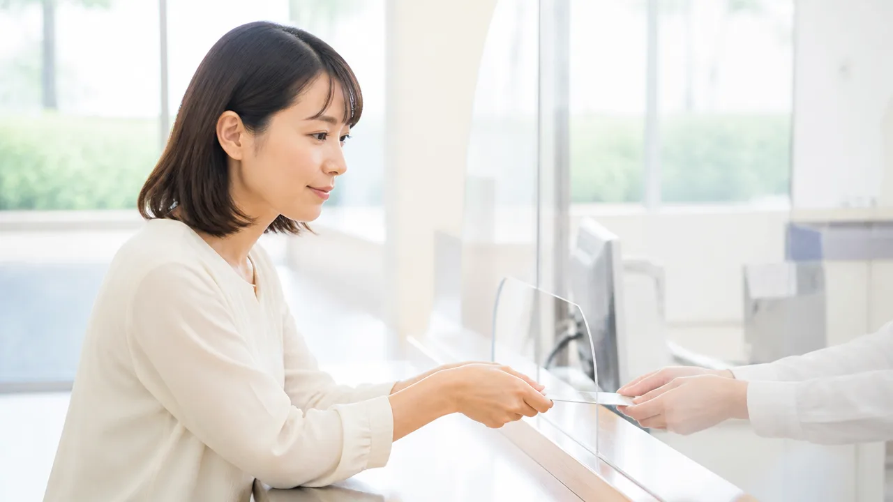 カウンターで書類を受け渡す人のイメージ