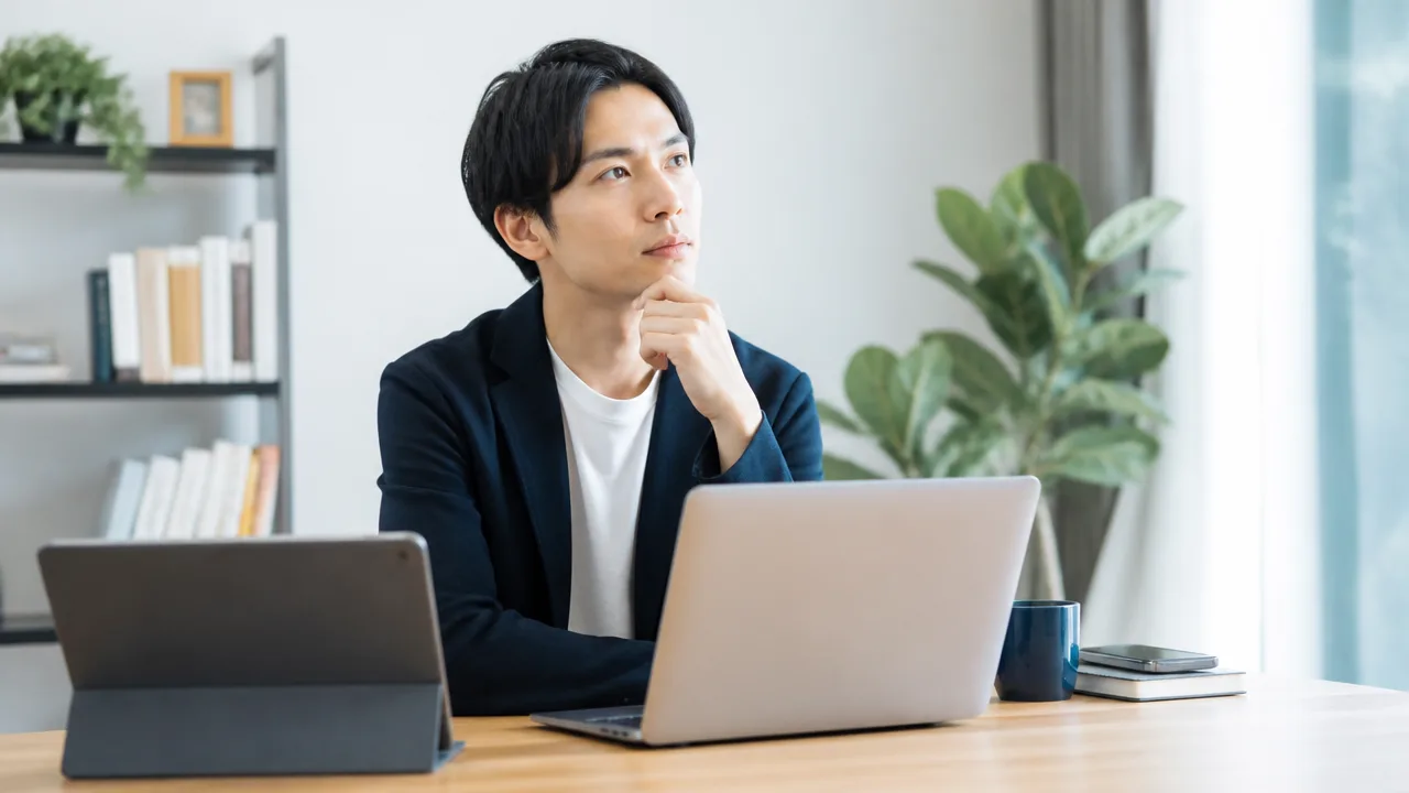 自宅でパソコンを前に働き方を考える人のイメージ