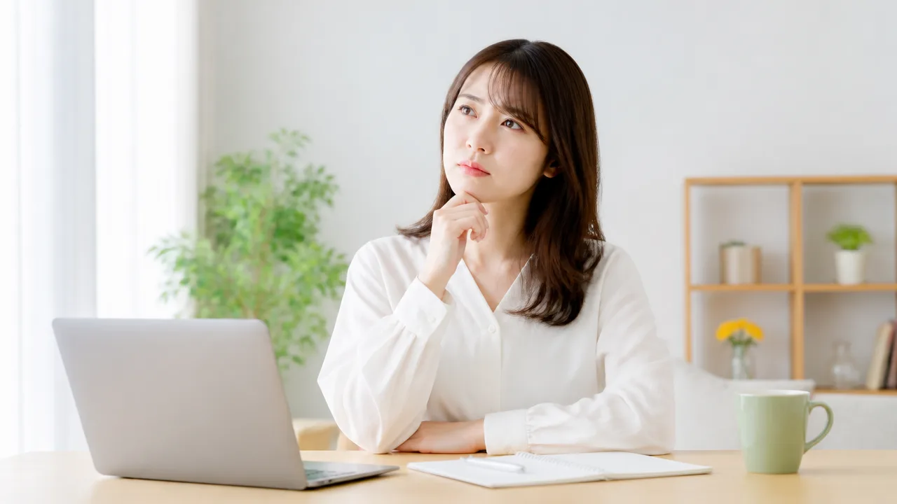パソコンとノートを前に考える人のイメージ